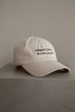 beige baseball cap sitting on top of a concrete table